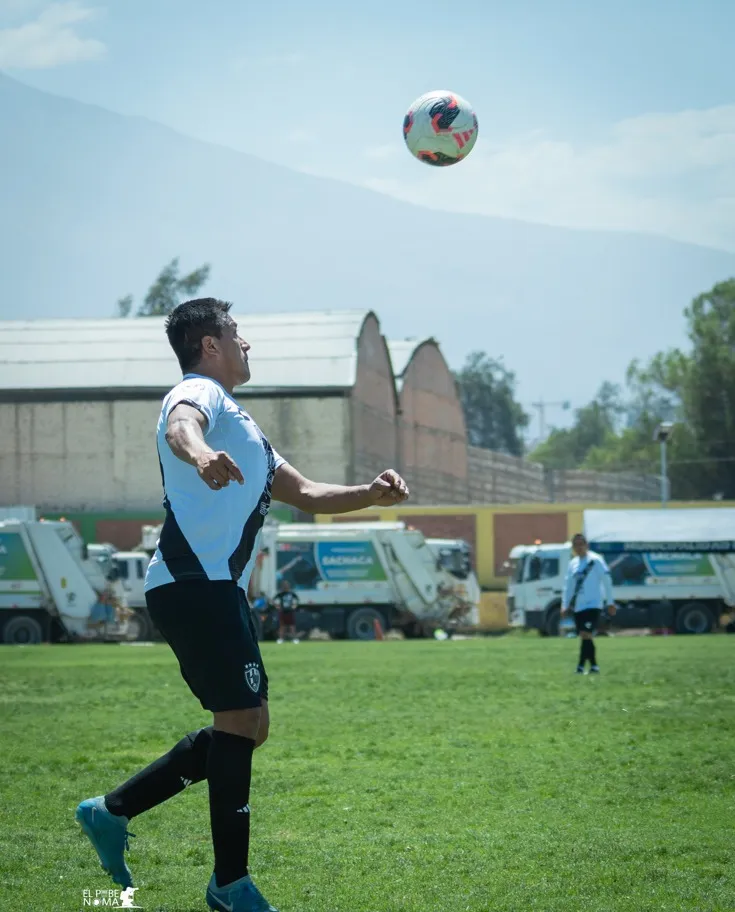 Jugador de Cuervos 23 AQP mira el balón elevado con el cielo de Arequipa detrás.