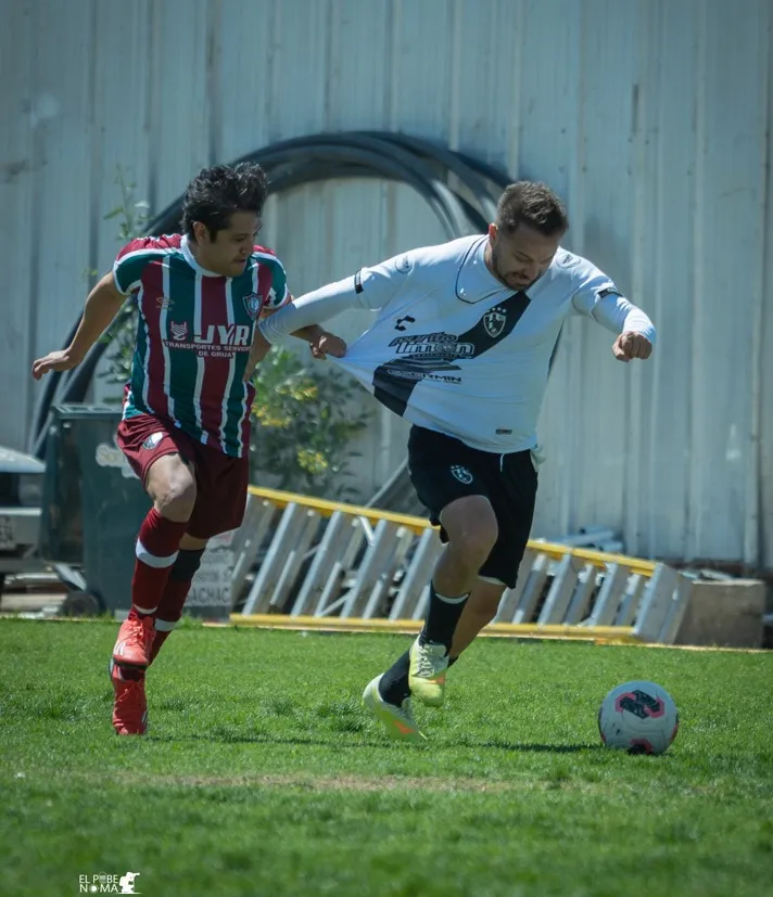 Jugador de Cuervos 23 AQP protege el balón cerca de la línea ante un rival.