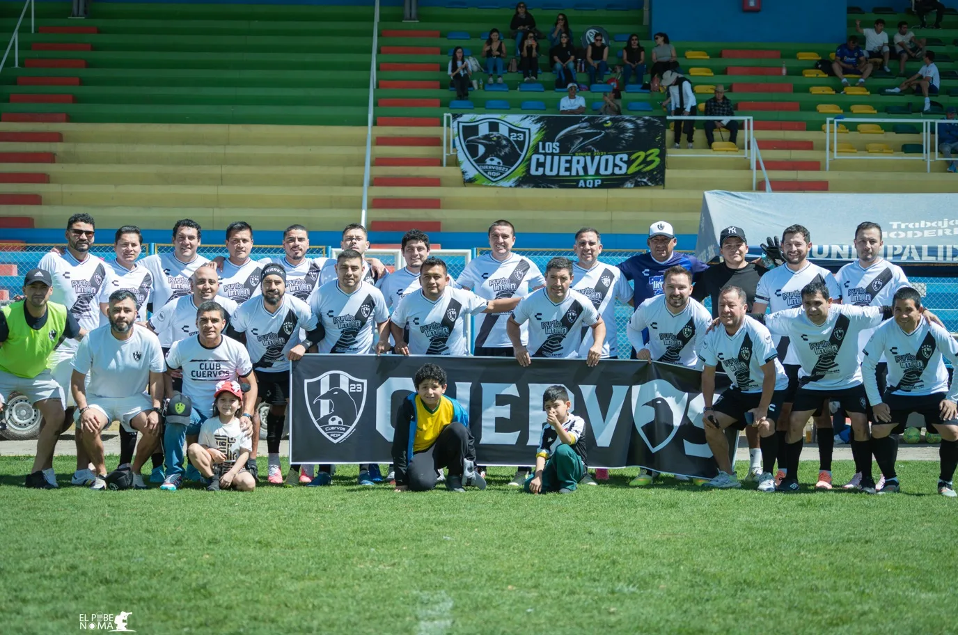Plantel campeón de Cuervos 23 AQP posando con la bandera del club.